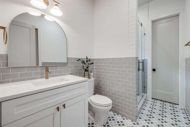 2231 Colquitt St, Houston, TX 77098 - full bath with tile walls, a stall shower, toilet, vanity, and a wainscoted wall