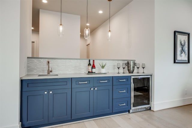 2231 Colquitt St, Houston, TX 77098 - indoor wet bar with beverage cooler, light wood-type flooring, pendant lighting, backsplash, and baseboards