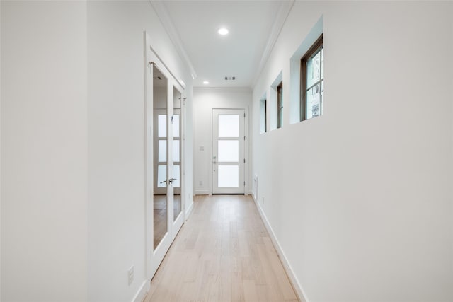 hallway featuring light hardwood / wood-style flooring and ornamental molding