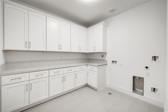 laundry room featuring electric dryer hookup, cabinets, hookup for a washing machine, and light tile patterned floors