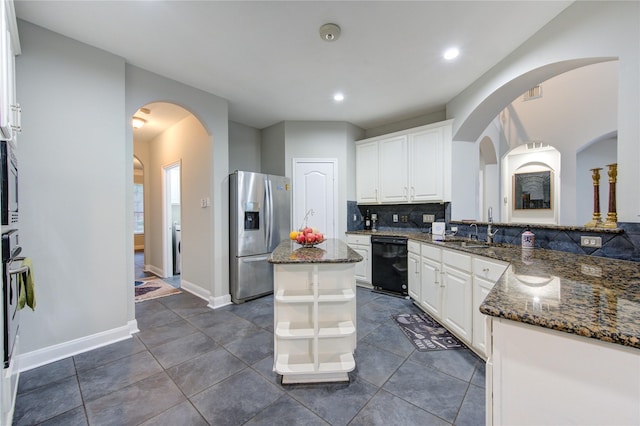 kitchen featuring stainless steel refrigerator with ice dispenser, white cabinetry, dark stone counters, and black dishwasher