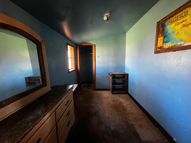 hallway with dark colored carpet