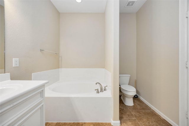 bathroom featuring a tub to relax in, toilet, and vanity