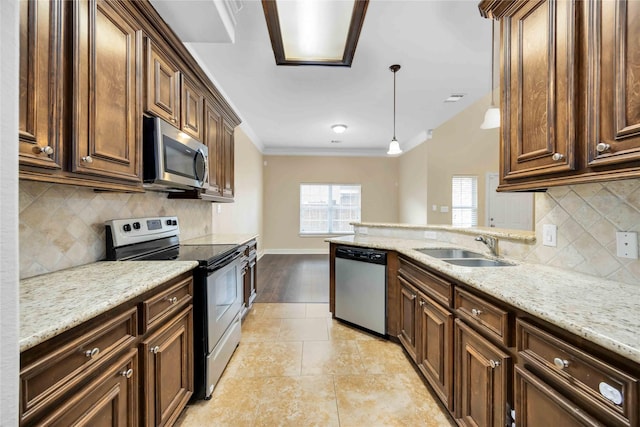 kitchen featuring sink, crown molding, appliances with stainless steel finishes, hanging light fixtures, and light stone countertops