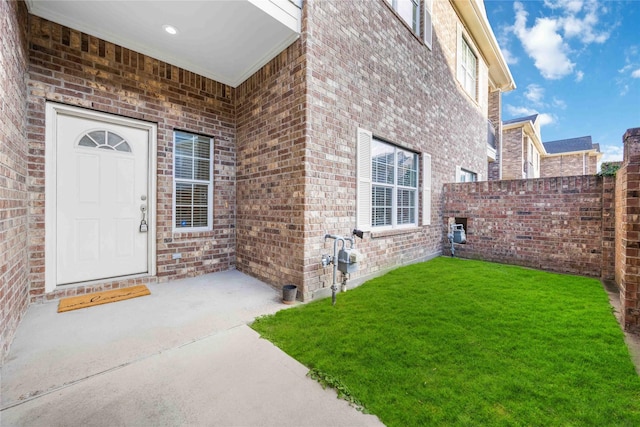 doorway to property featuring a yard and a patio area