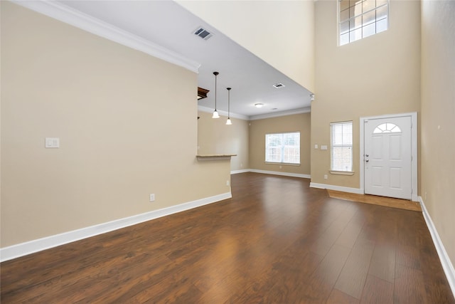 entrance foyer with crown molding, dark wood-type flooring, and a high ceiling