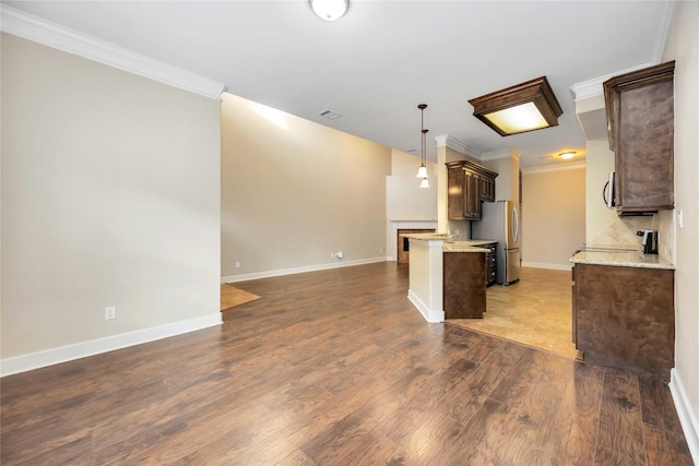 kitchen featuring decorative backsplash, wood-type flooring, ornamental molding, and stainless steel refrigerator