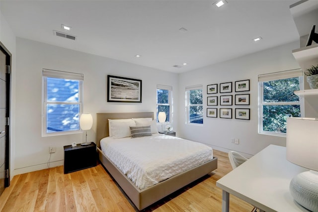 bedroom with light hardwood / wood-style floors and multiple windows