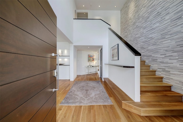 stairway with hardwood / wood-style flooring and a high ceiling