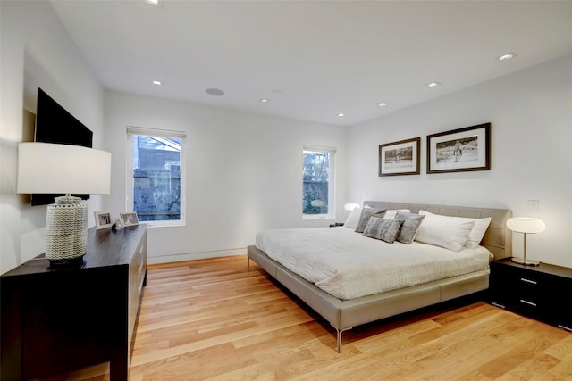 bedroom with multiple windows and light hardwood / wood-style floors