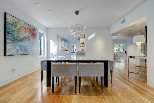 dining area featuring a notable chandelier and light hardwood / wood-style flooring