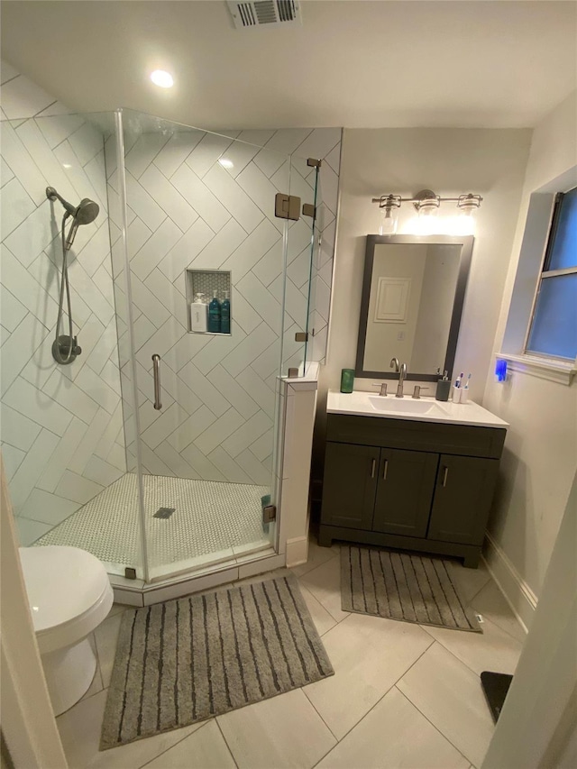 bathroom with an enclosed shower, toilet, tile patterned floors, and vanity