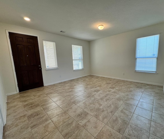 tiled entrance foyer featuring a textured ceiling