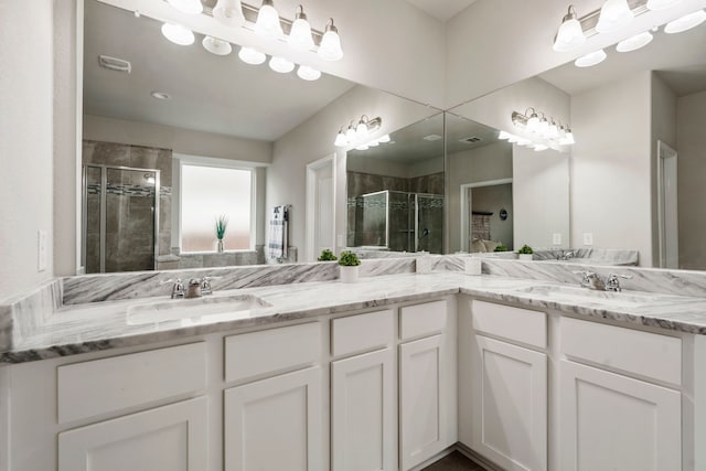 bathroom with vanity and a shower with door