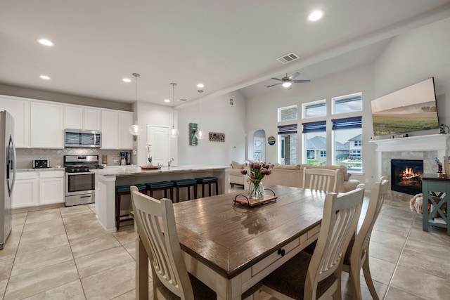 dining area with sink, light tile patterned floors, and ceiling fan