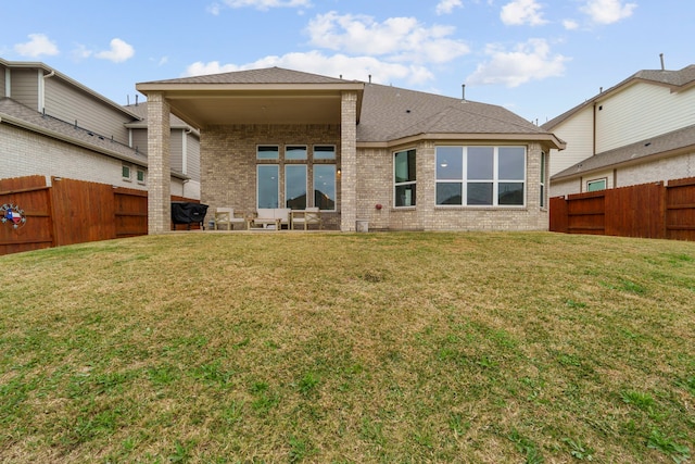 rear view of house featuring a lawn