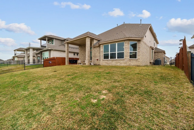 rear view of property with a yard and central air condition unit