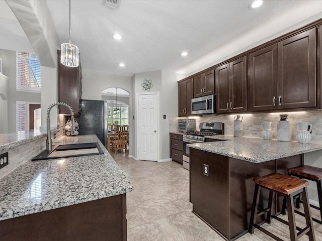 kitchen with sink, light stone counters, and stainless steel appliances