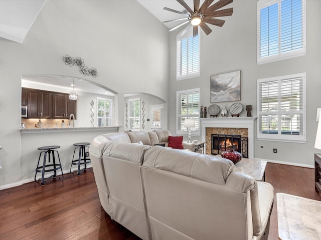 living room with a healthy amount of sunlight, high vaulted ceiling, and dark hardwood / wood-style flooring