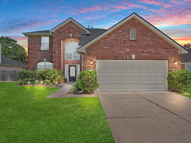 view of front property featuring a garage and a yard