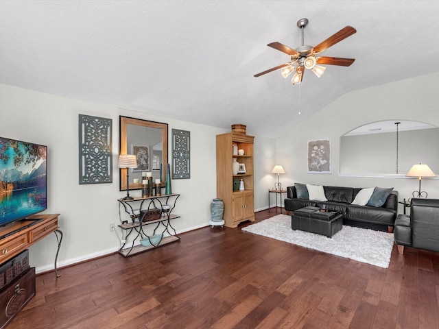 living room featuring ceiling fan, dark hardwood / wood-style floors, and vaulted ceiling