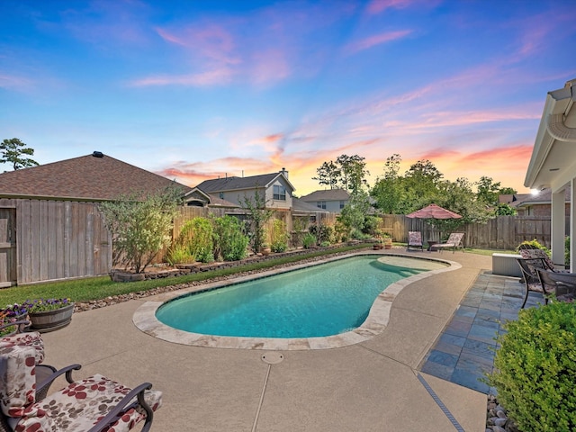 pool at dusk with a patio area