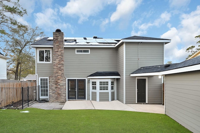 rear view of property featuring a patio area and a lawn