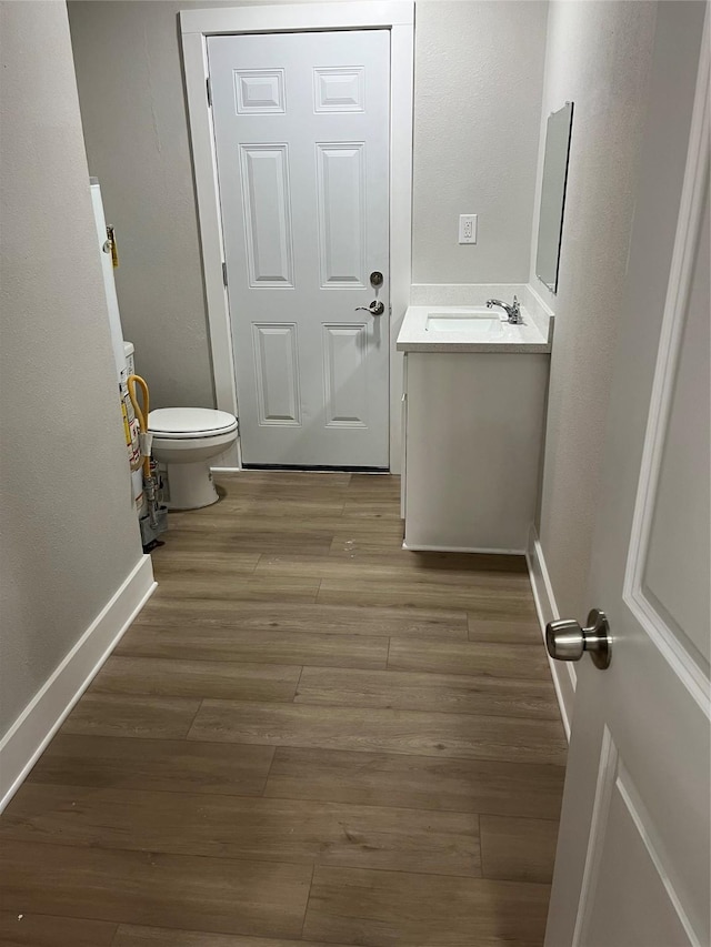 bathroom featuring vanity, hardwood / wood-style floors, and toilet