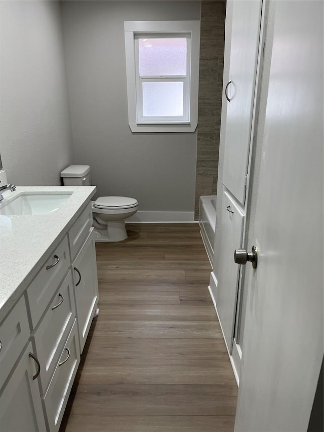 bathroom featuring vanity, hardwood / wood-style flooring, and toilet