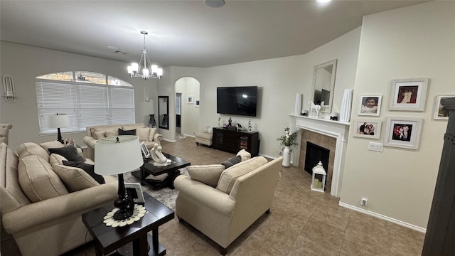 living room with a notable chandelier, tile patterned flooring, and a tiled fireplace