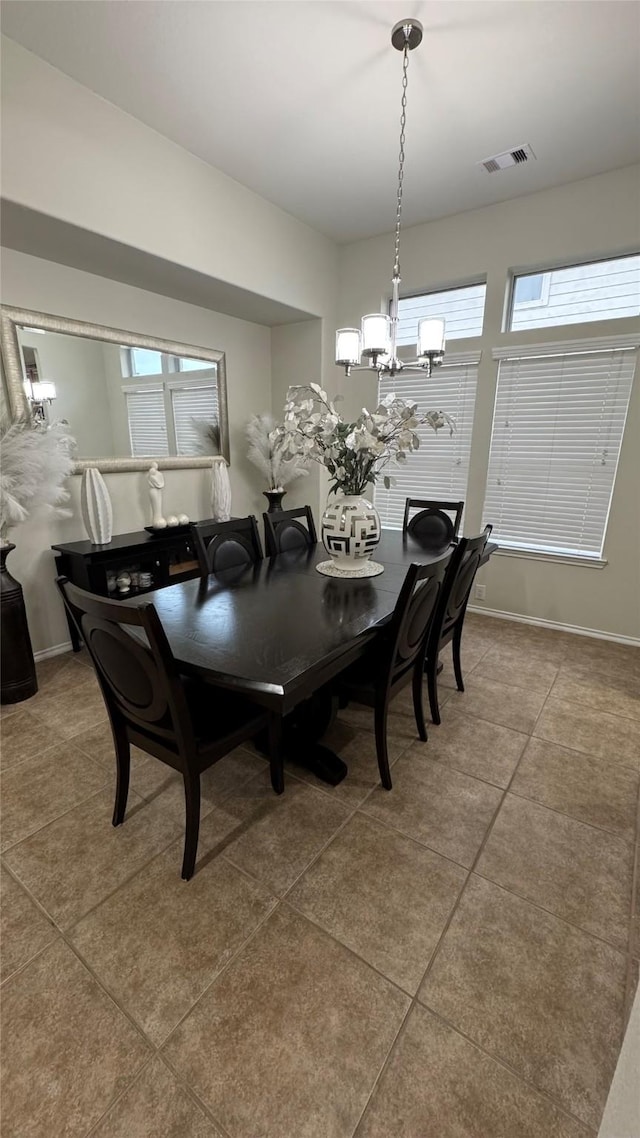 dining room featuring tile patterned floors and an inviting chandelier