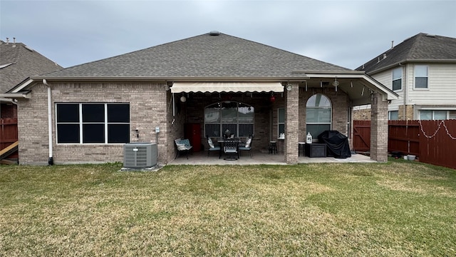 rear view of property featuring a yard, a patio, and central AC