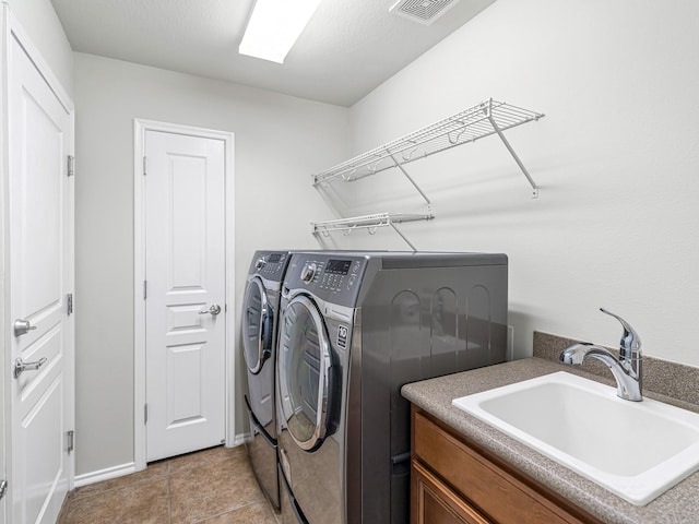 laundry area featuring sink, light tile patterned floors, and independent washer and dryer