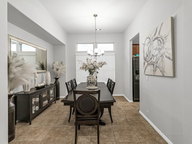 tiled dining room with a notable chandelier and a healthy amount of sunlight