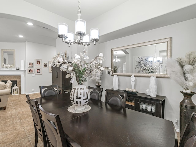 tiled dining room with an inviting chandelier and a tiled fireplace