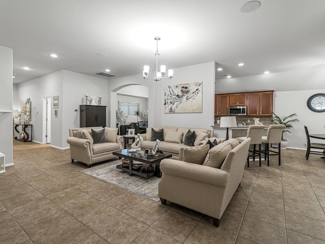 living room with dark tile patterned flooring and a chandelier