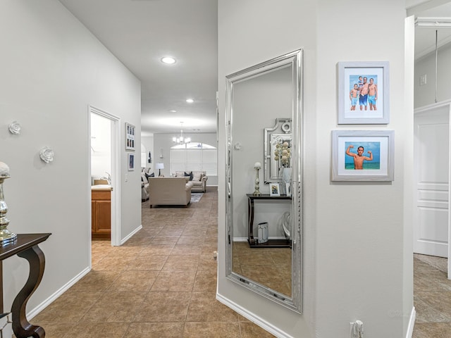 hallway with an inviting chandelier, sink, and light tile patterned floors