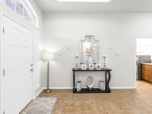 tiled entrance foyer featuring washer / dryer