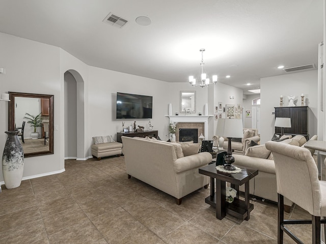 living room with a fireplace, a chandelier, and tile patterned flooring