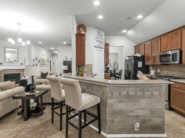 kitchen with backsplash, stainless steel appliances, a kitchen breakfast bar, light tile patterned flooring, and decorative light fixtures