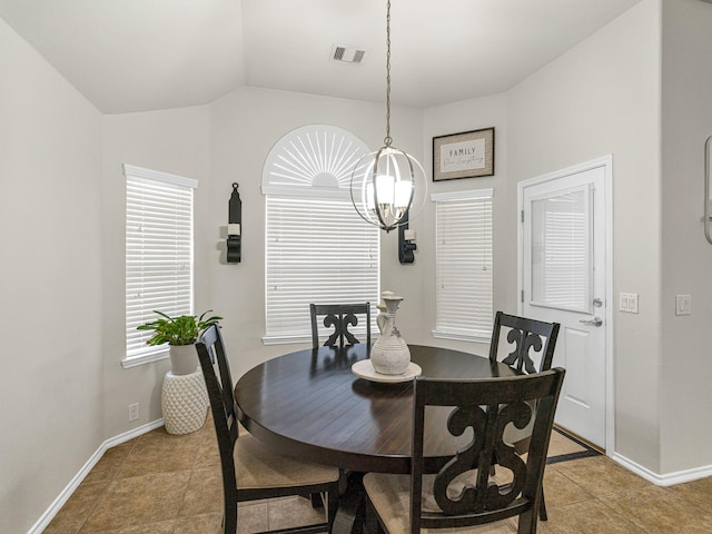 tiled dining room featuring vaulted ceiling and a notable chandelier