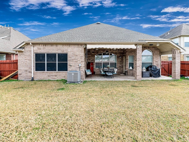 back of property with cooling unit, a patio area, and a lawn