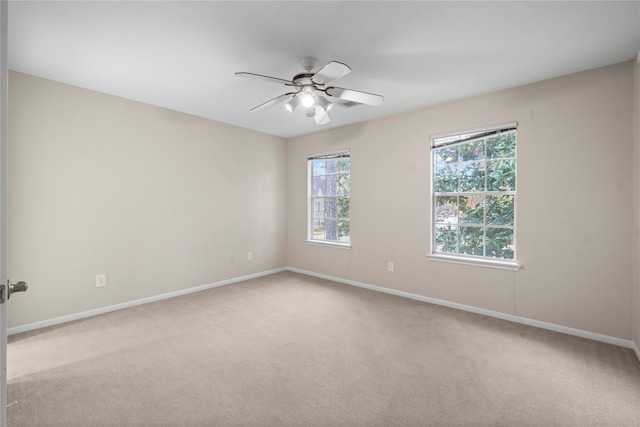 spare room with light colored carpet and ceiling fan