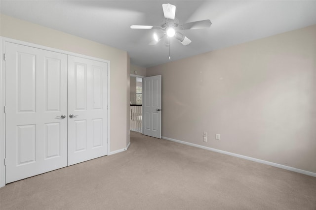 unfurnished bedroom featuring ceiling fan, a closet, and light carpet