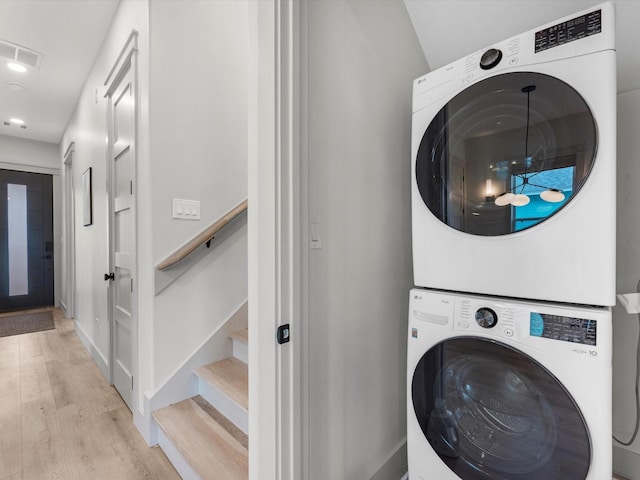 washroom featuring stacked washer / drying machine and light wood-type flooring