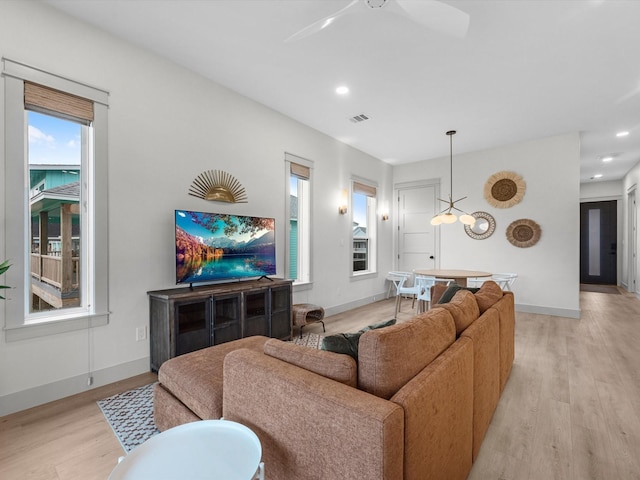 living room featuring ceiling fan and light wood-type flooring