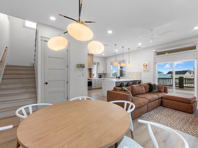 dining area featuring light hardwood / wood-style floors, ceiling fan, plenty of natural light, and sink