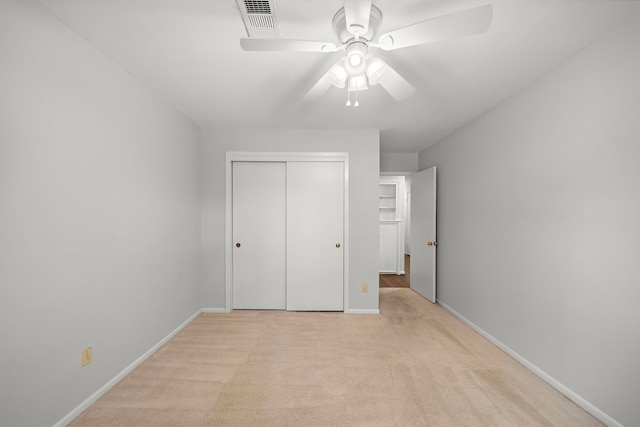 unfurnished bedroom with a closet, ceiling fan, and light carpet