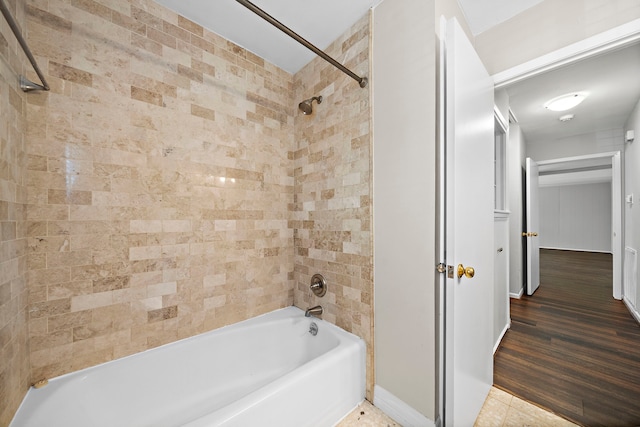 bathroom with tiled shower / bath combo and tile patterned flooring