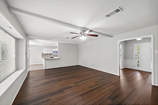 unfurnished living room featuring ceiling fan, beamed ceiling, and dark hardwood / wood-style flooring